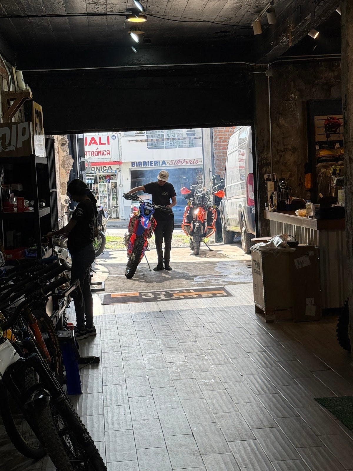 Interior de JAX Moto Lab con motocicletas y personas