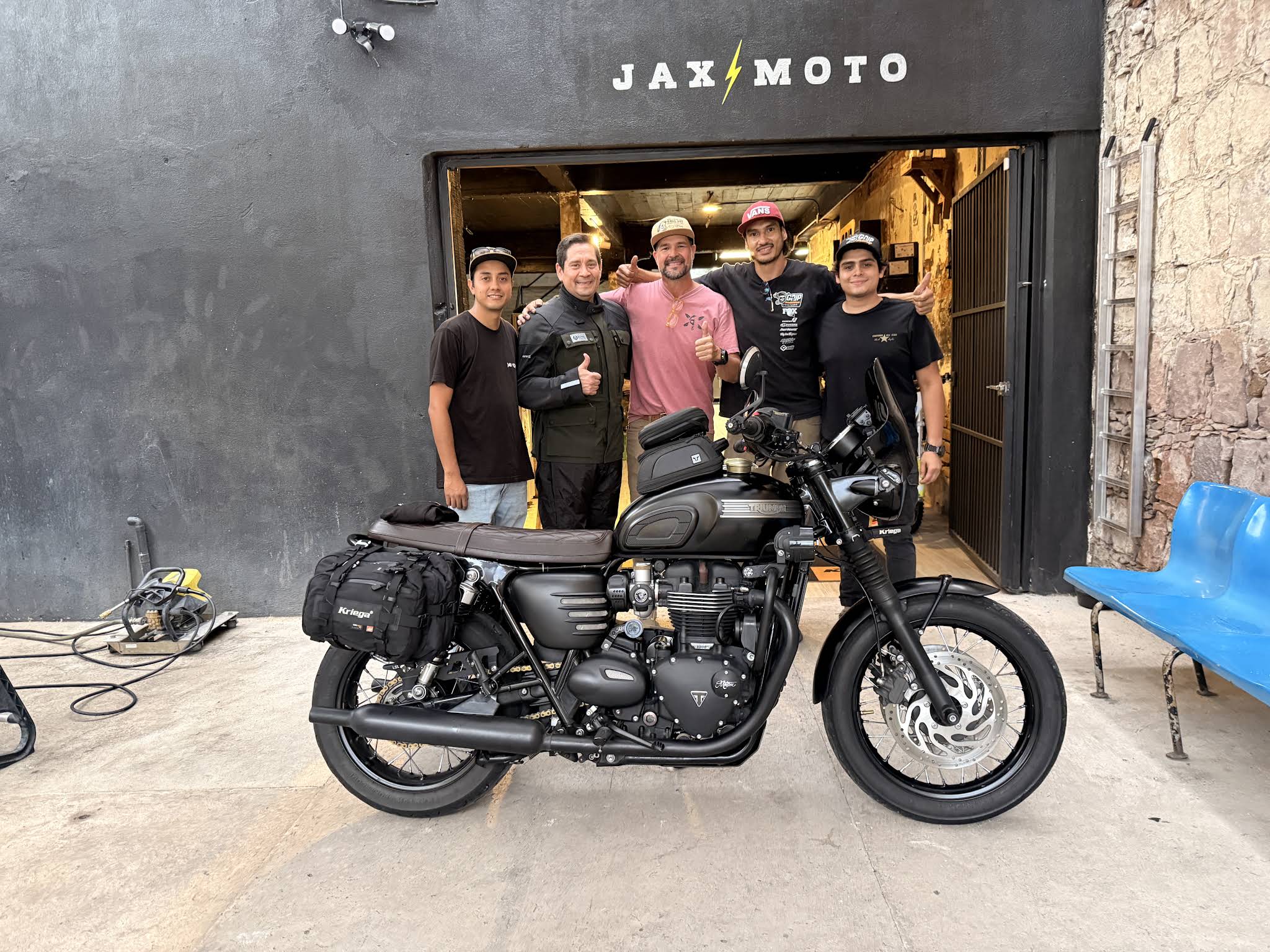 Fachada de JAX Moto Lab en León con el equipo y una motocicleta