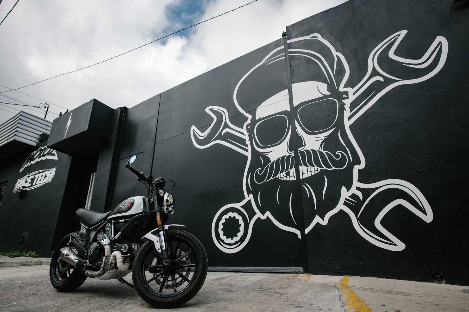 Motocicleta estacionada frente al mural exterior de JAX